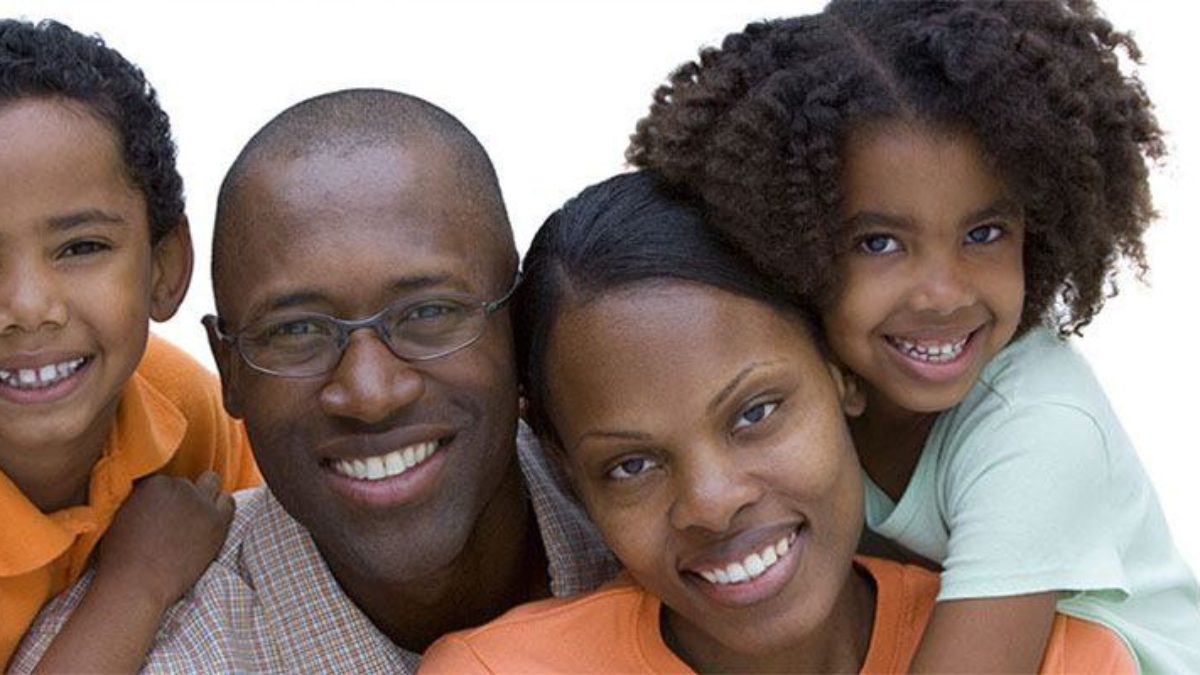 african parents smiling with their son and daughter
