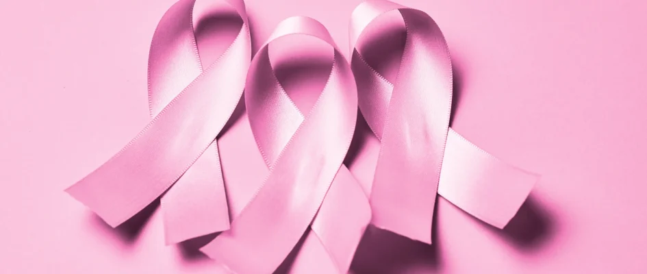 3 pink breast cancer ribbons with a pink background