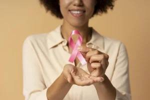 African woman holding pink breast cancer ribbon