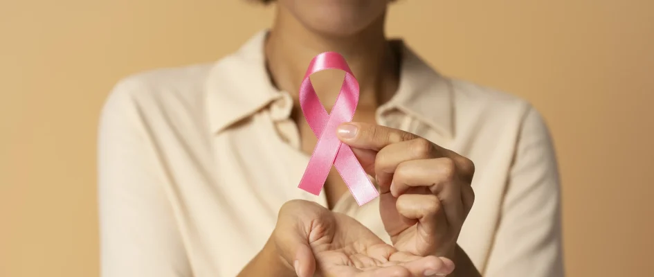 African woman holding pink breast cancer ribbon