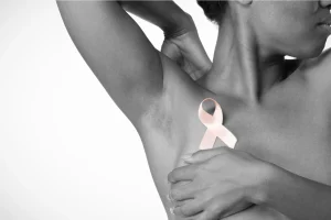 African woman holding pink breast cancer ribbon