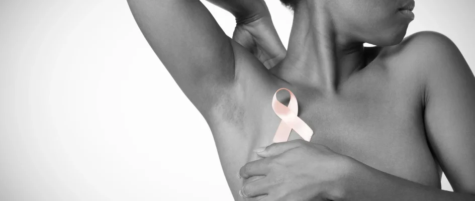 African woman holding pink breast cancer ribbon