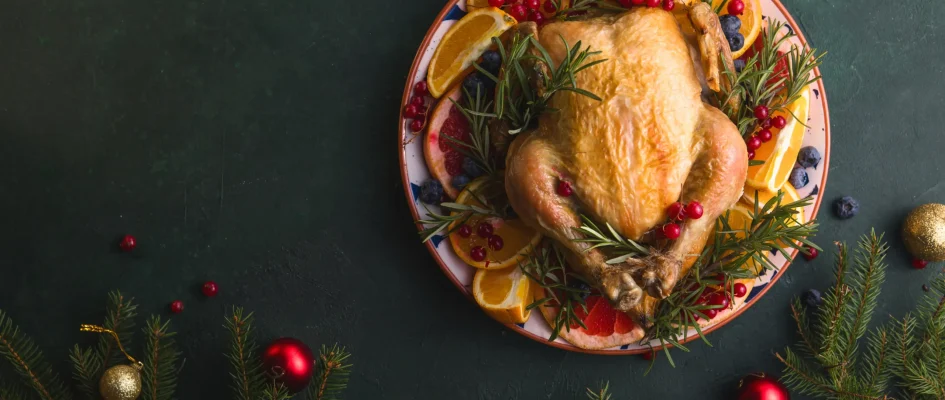 Roast Chicken served on a dish with Christmas decorations the table