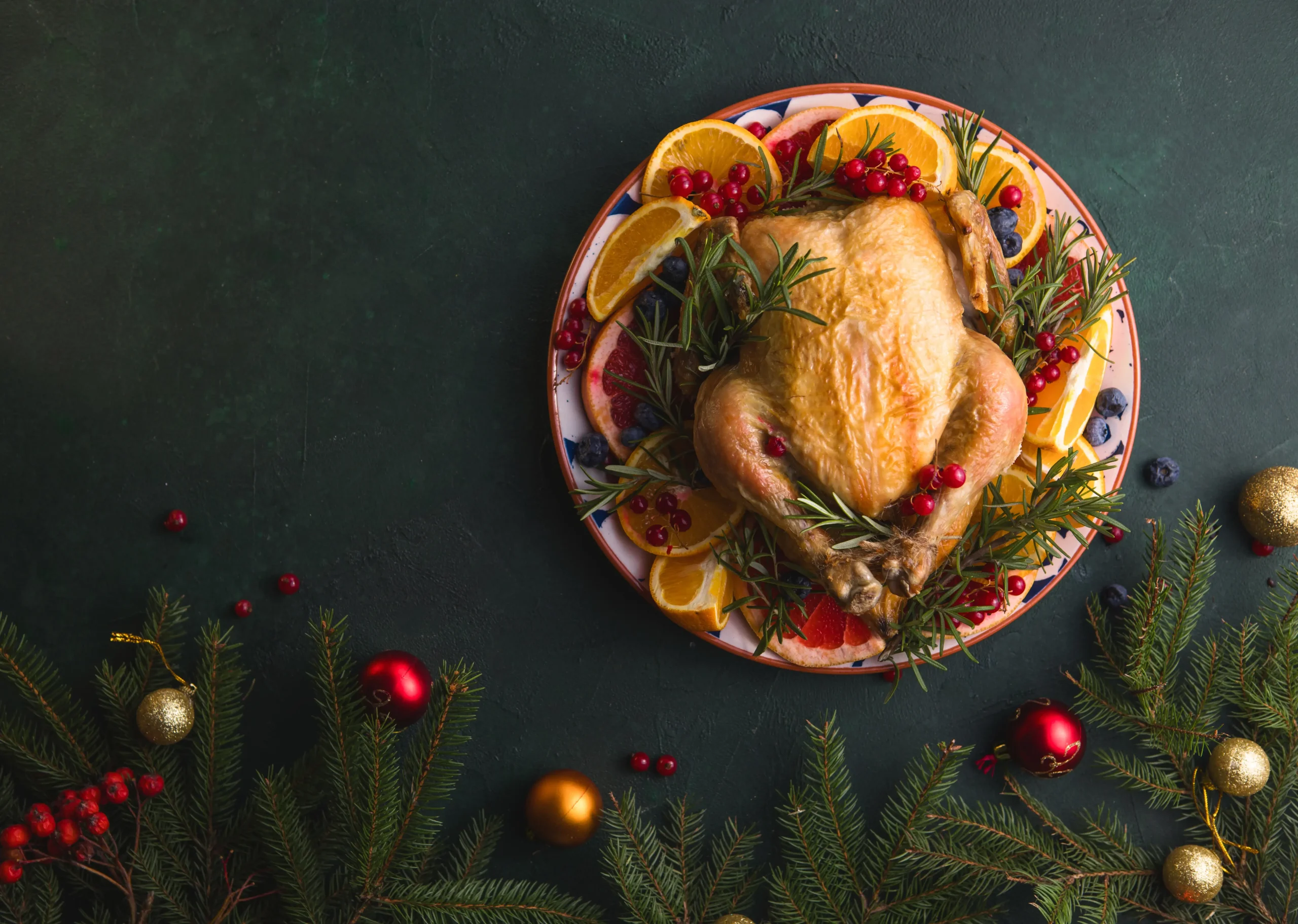 Roast Chicken served on a dish with Christmas decorations the table