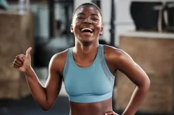 African woman in sports attire giving a thumbs up