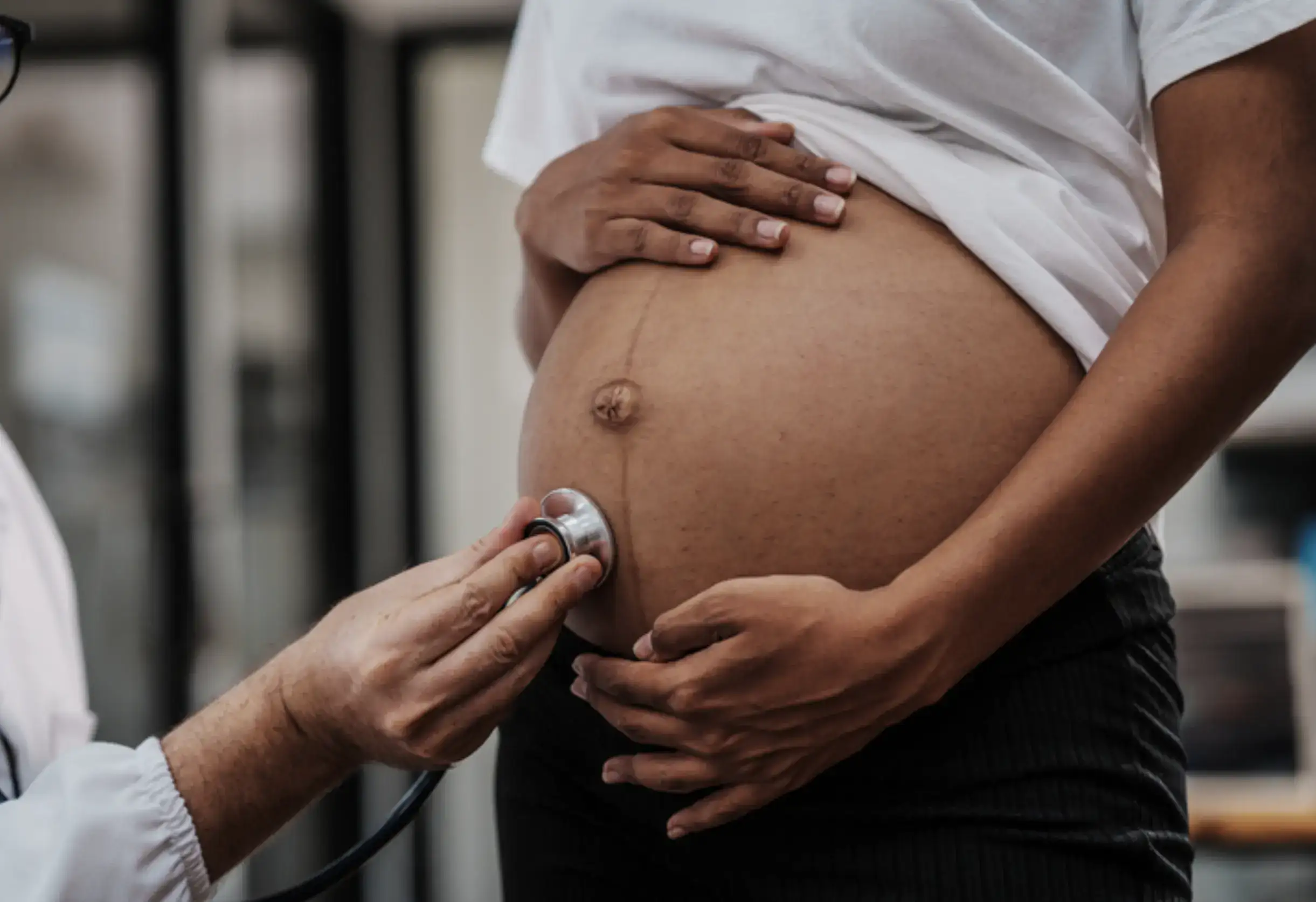 African female with pregnant belly undergoing examination from a male gynaecologist