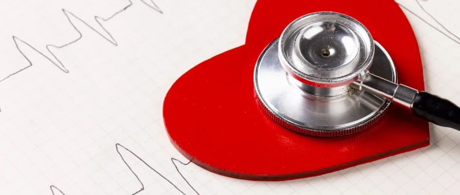 Red heart on cardiogram with stethoscope atop