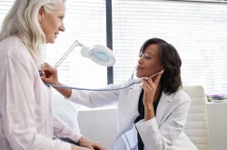 Woman Doctor using stethoscope to check vitals of a female patient