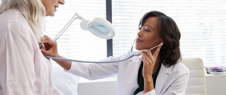 Woman Doctor using stethoscope to check vitals of a female patient