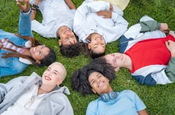 Group of young adults laying in a circle