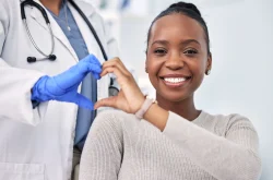 African patient and doctor forming heart shape with their hands