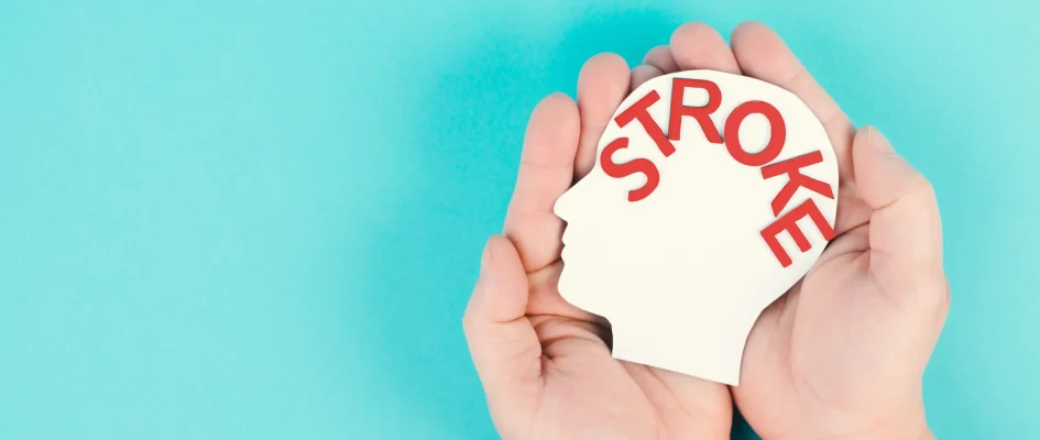 Hands holding plastic head with stroke written on head.