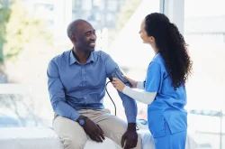 Doctor taking male patient's blood pressure
