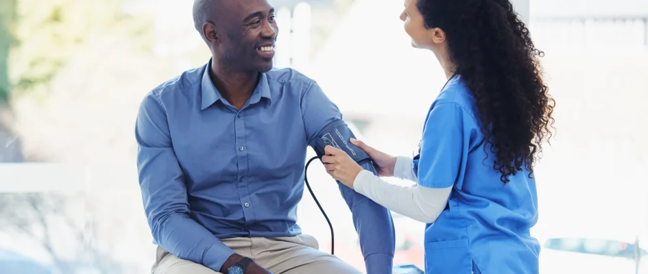 Doctor taking male patient's blood pressure