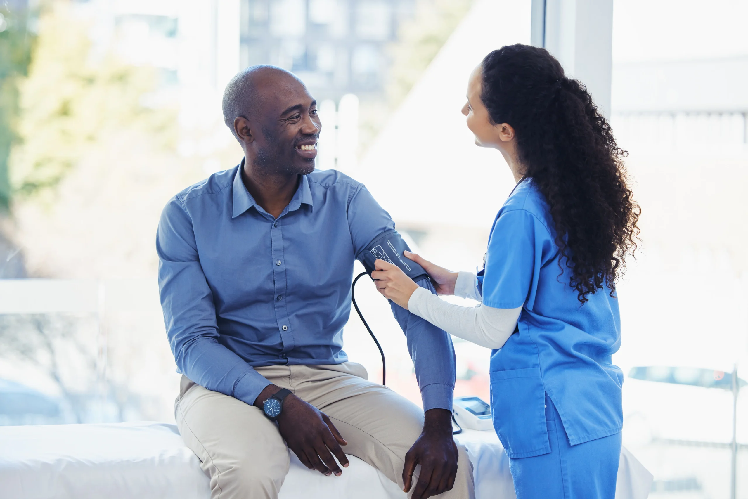 Doctor taking male patient's blood pressure