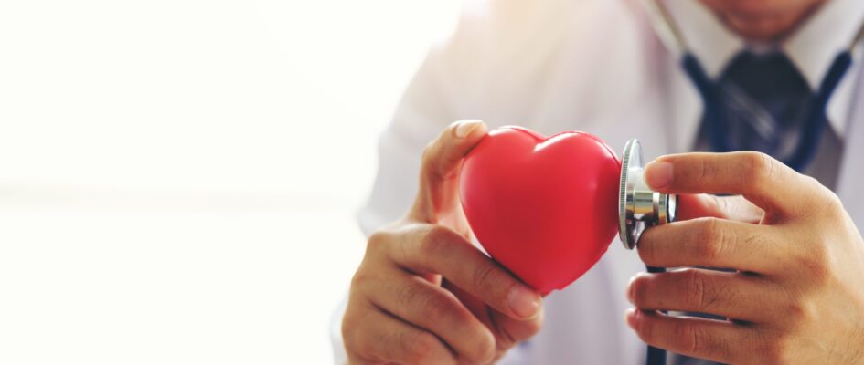 doctor holding hands with red heart in clinic office, Healthy li Doctor holding heart in hands with stethoscope