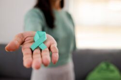 Woman Holding Teal Ribbon for January Cervical Cancer Awareness Month.