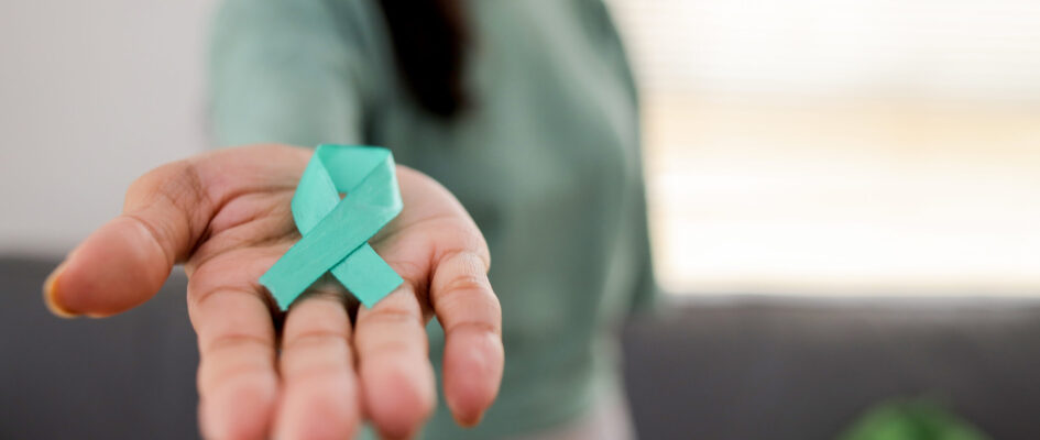 Woman Holding Teal Ribbon for January Cervical Cancer Awareness Month.