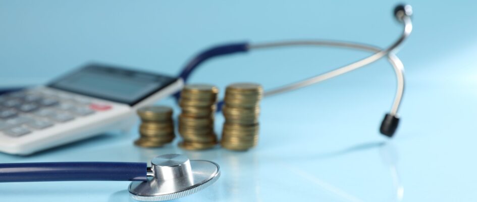 Stethoscope, calculator and coins on light blue background, closeup Stethoscope, calculator and coins on light blue background, closeup