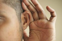 young man having ear pain touching his painful ear , young man having ear pain touching his painful ear