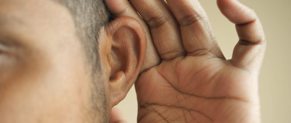 young man having ear pain touching his painful ear , young man having ear pain touching his painful ear