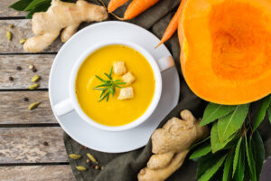 Seasonal spicy fall autumn creamy pumpkin and carrot soup bright orange soup with croutons and ginger