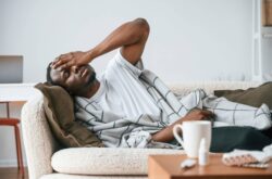 man-resting-on-sofa-feeling-unwell man-resting-on-sofa-feeling-unwell