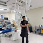 Doctor's assistant standing with his arms crossed in an operating room