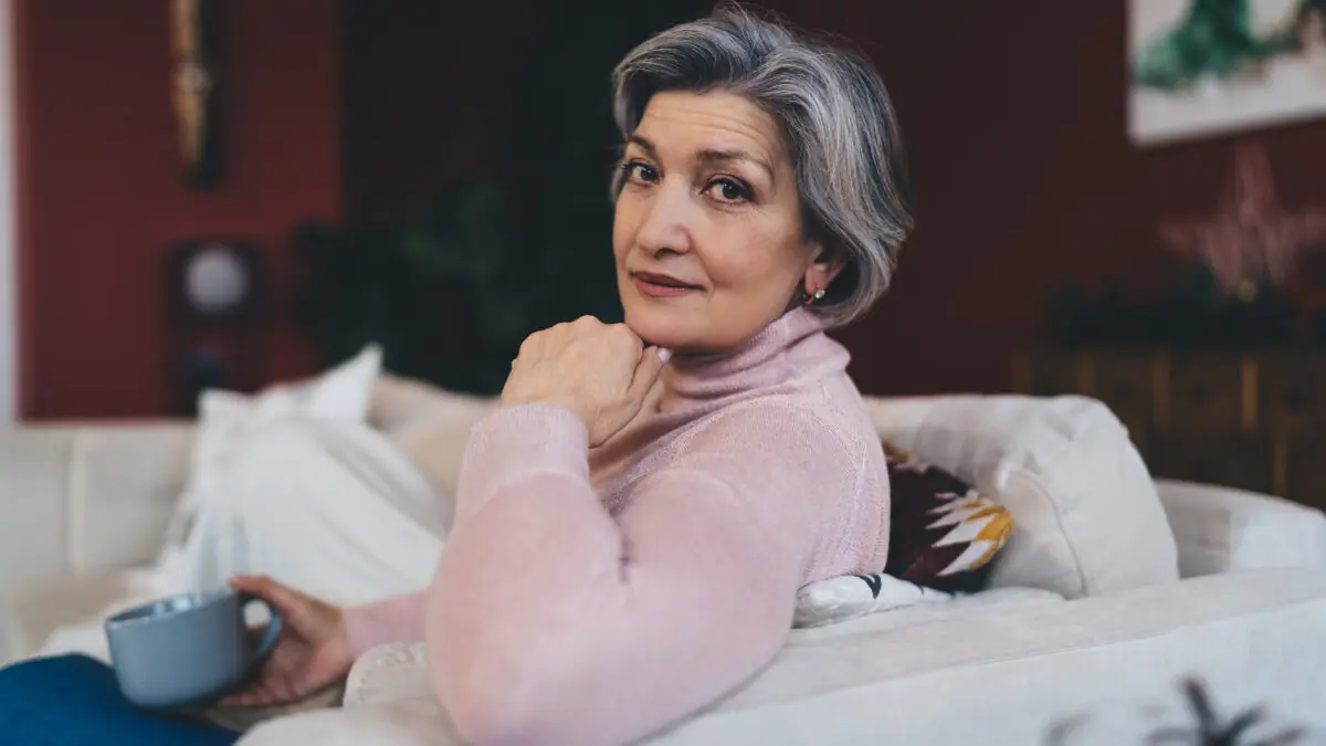 thoughtful senior woman relaxing on sofa at home