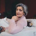 thoughtful senior woman relaxing on sofa at home