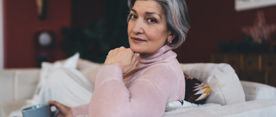 thoughtful senior woman relaxing on sofa at home