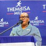 Lady of the Thembisa Mile standing on a podium talking into a microphone
