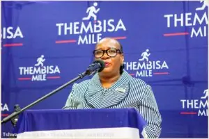 Lady of the Thembisa Mile standing on a podium talking into a microphone Lady of the Thembisa Mile standing on a podium talking into a microphone