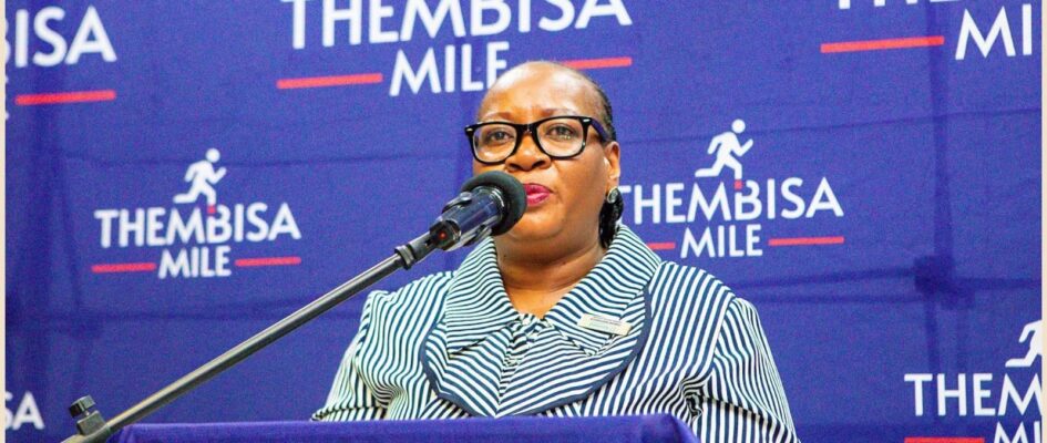 Lady of the Thembisa Mile standing on a podium talking into a microphone Lady of the Thembisa Mile standing on a podium talking into a microphone