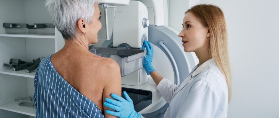 Senior woman having mammography scan at hospital with medical technician. Mammography procedure, breast cancer prevention Senior woman having mammography scan at hospital with medical technician. Mammography procedure, breast cancer prevention