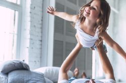 Dad playing with daughter in the bed