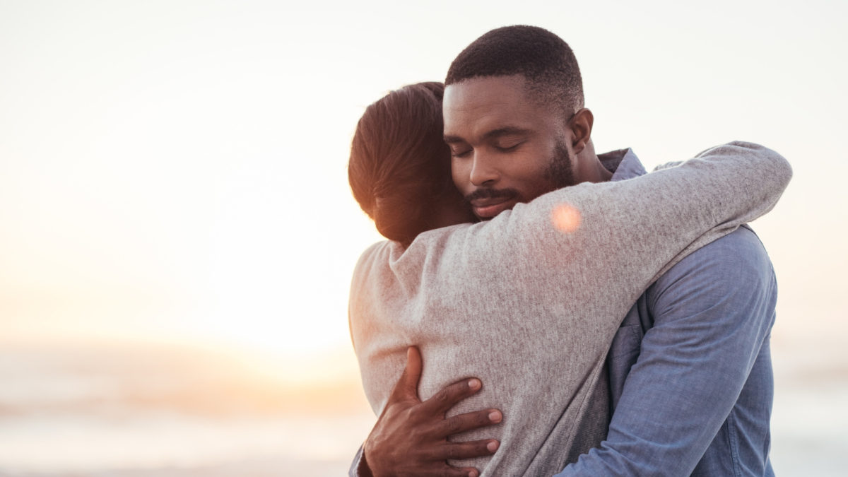 african couple hugging with sunset background