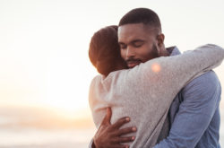 african couple hugging with sunset background