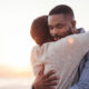 african couple hugging with sunset background