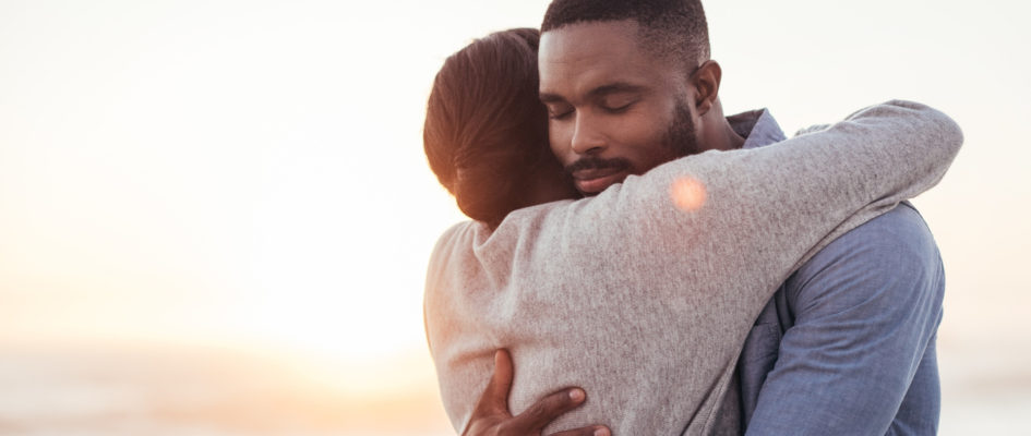 african couple hugging with sunset background