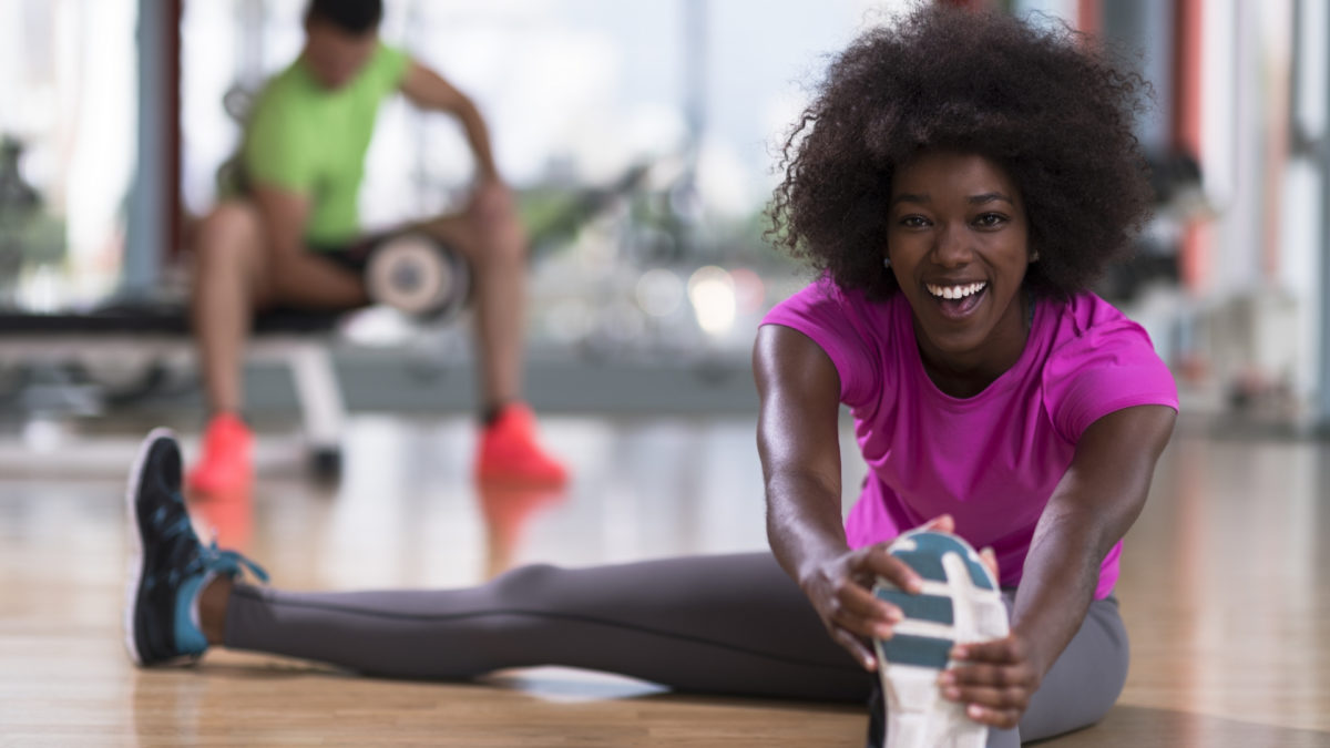 african woman stretching in the gym