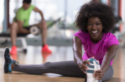 african woman stretching in the gym