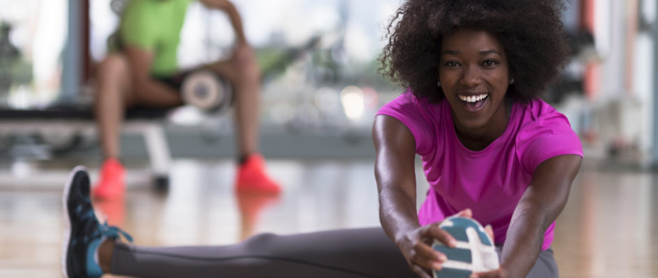 african woman stretching in the gym