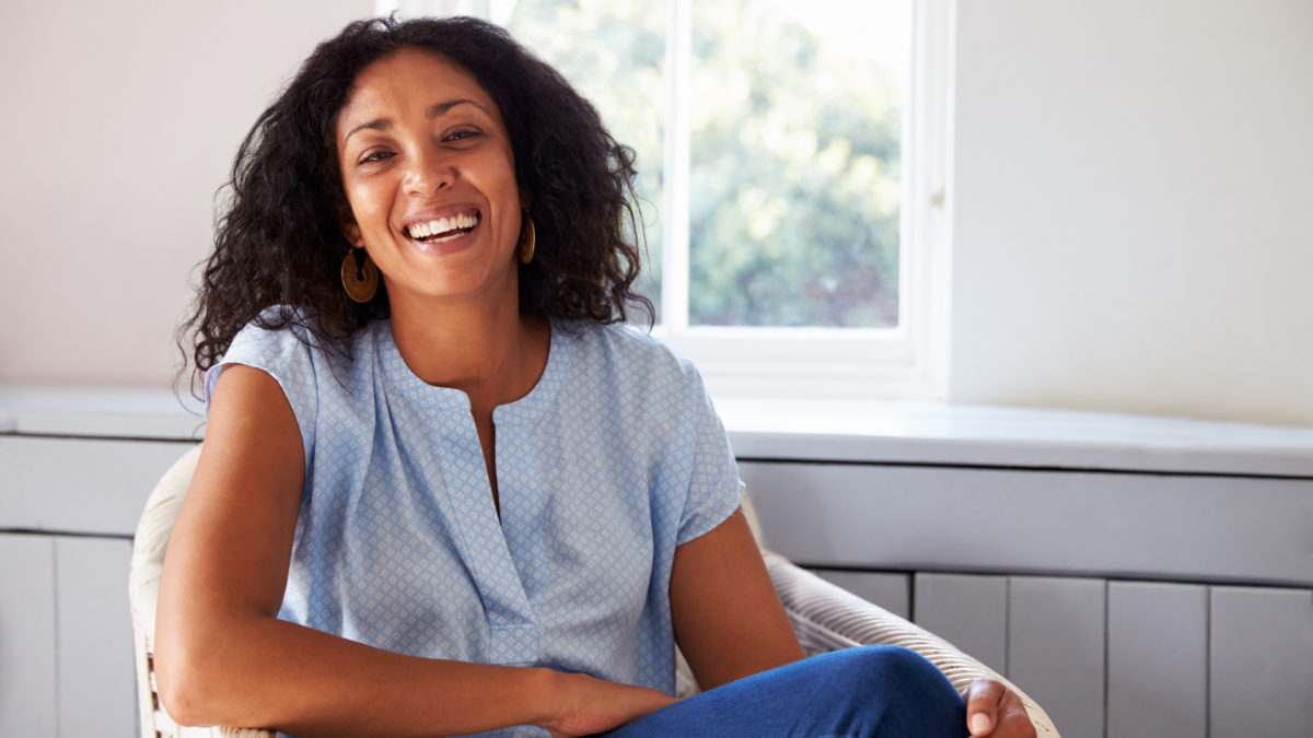 smiling african woman sitting on chair