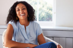 smiling african woman sitting on chair