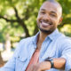 african man smiling while sitting on a bench