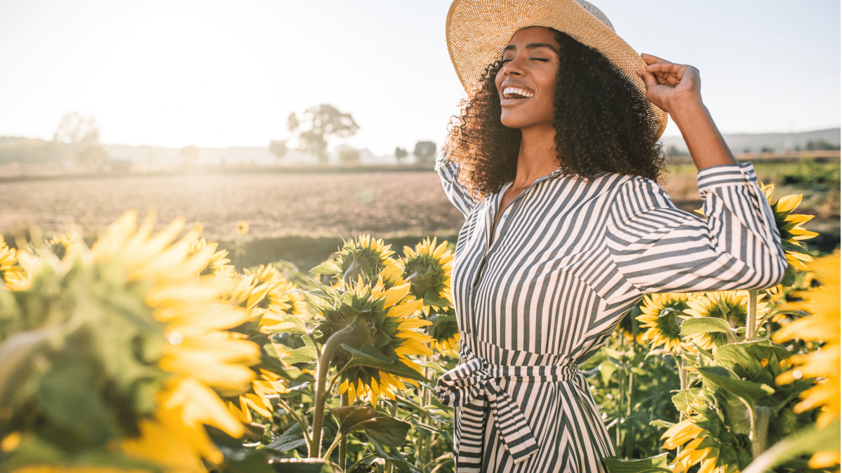 women smiling around sunflowers