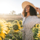 women smiling around sunflowers