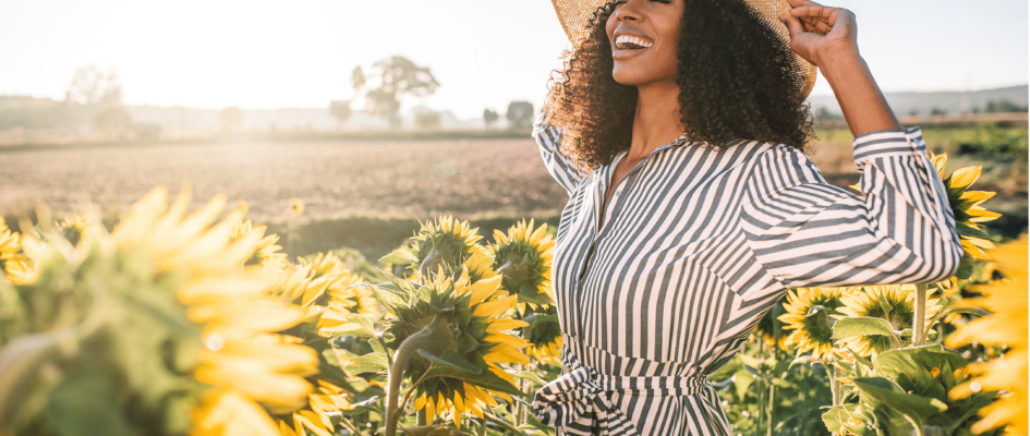 women smiling around sunflowers