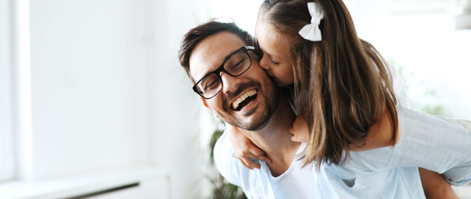 Portrait of father and daughter playing at home together